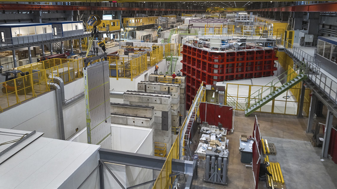 APA hanging from a crane as it is moved toward the red ProtoDUNE frame
